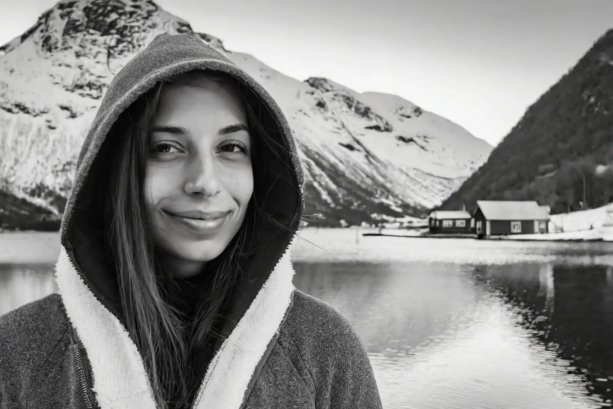 Image en noir et blanc générée par Firefly qui montre une femme scandinave devant un lac et la montagne en hiver.